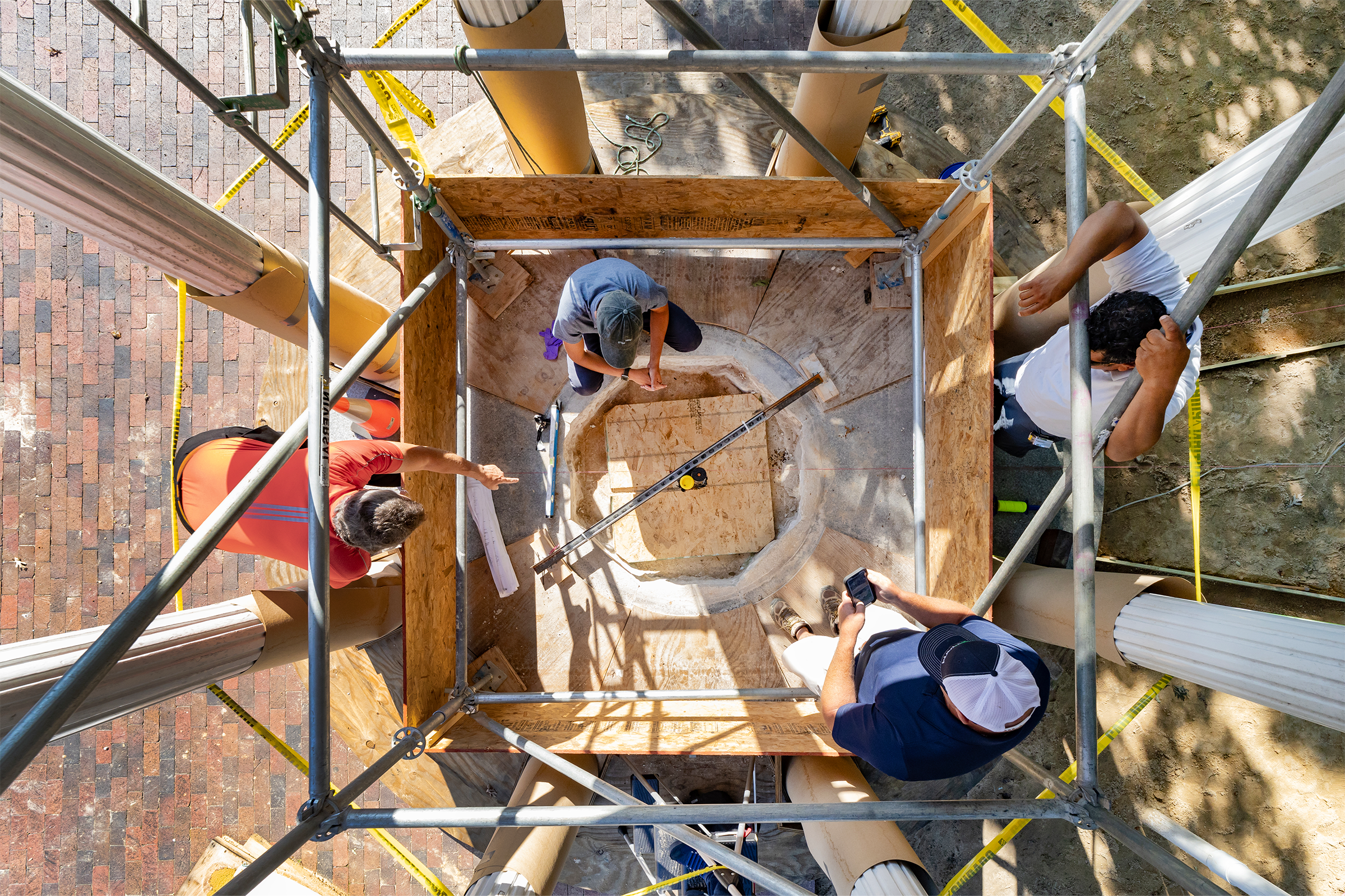 An overhead view of workers having a meeting in the interior of the Old Well structure.