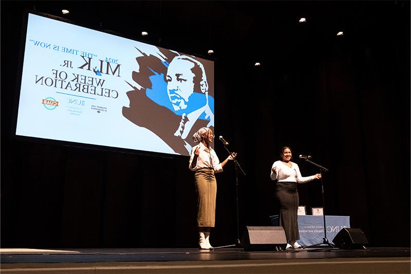 Two students on stage doing a poetry reading performance.