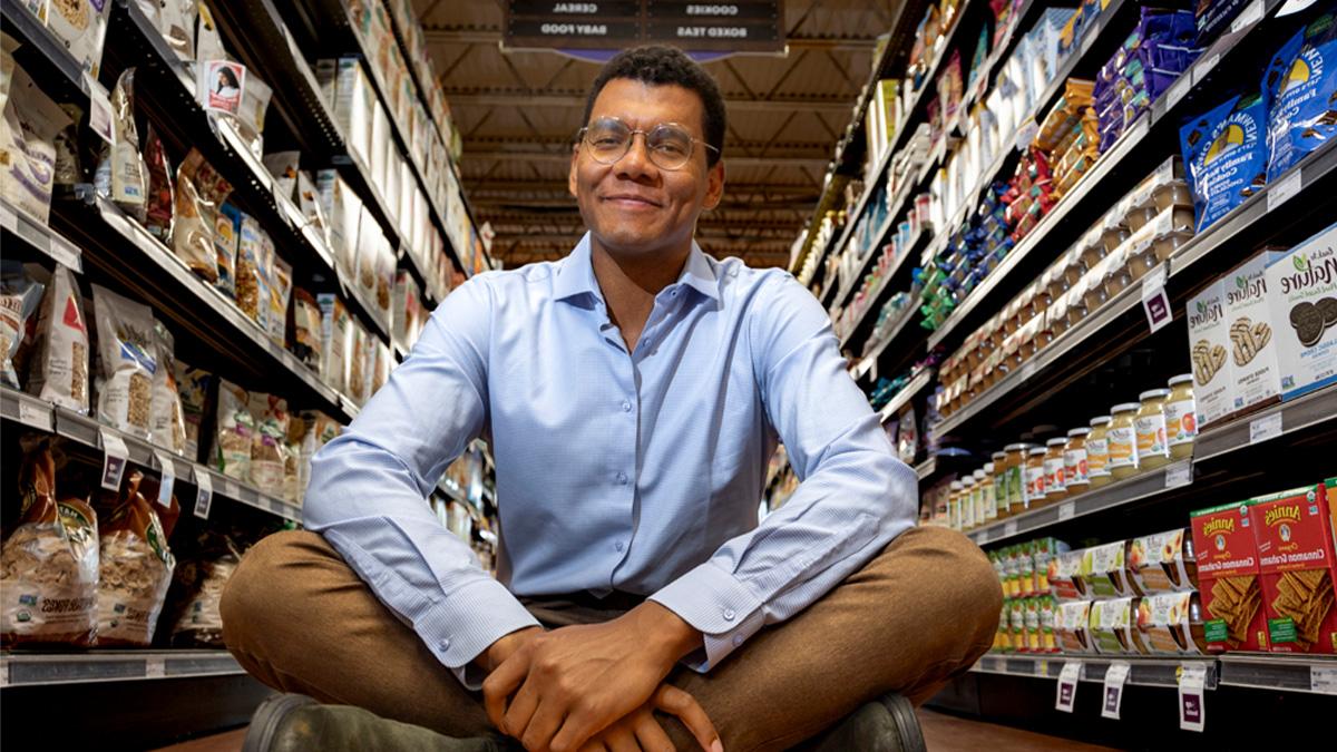 Emile Charles sitting down 在 middle of an aisle inside of a grocery store.